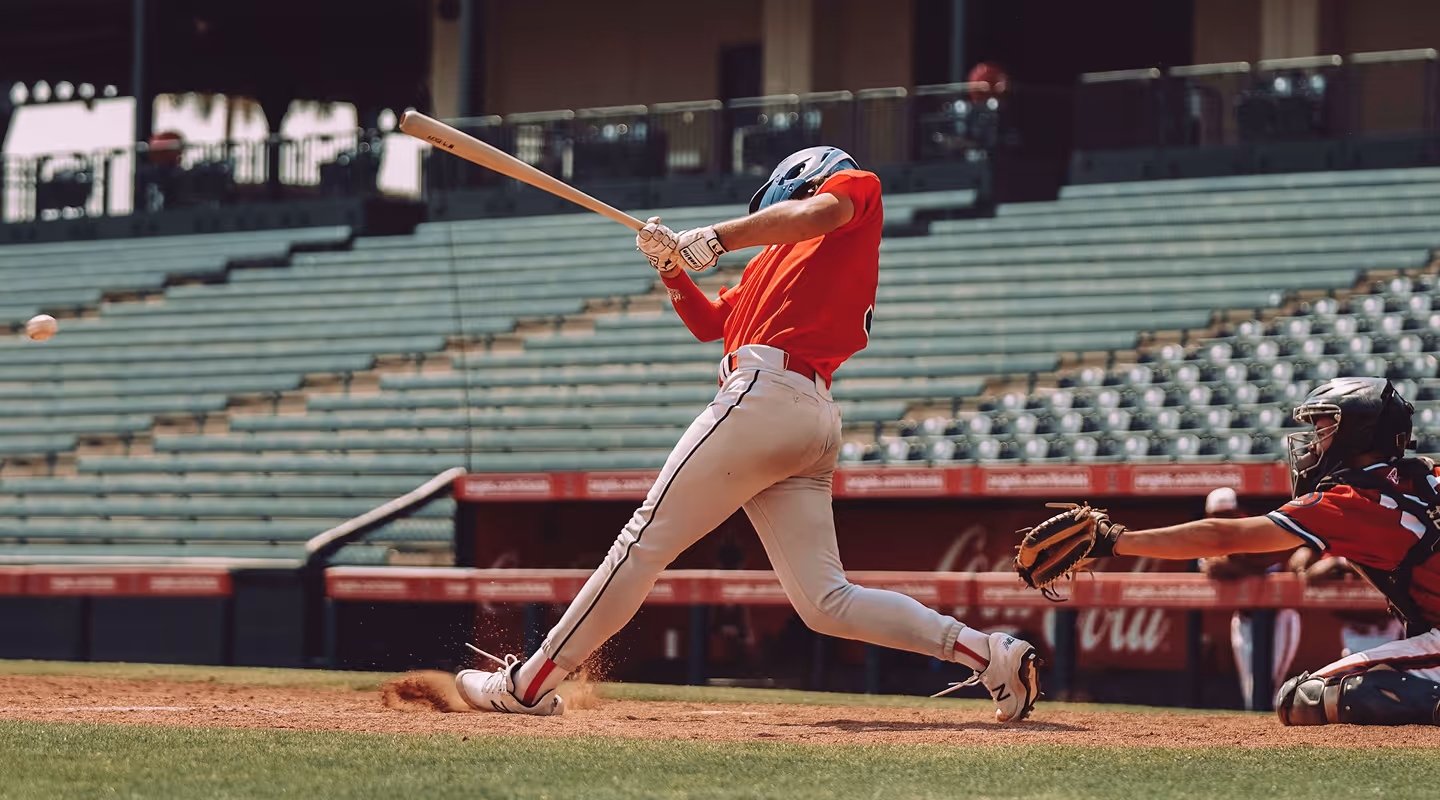 A baseball player swings at a pitch.